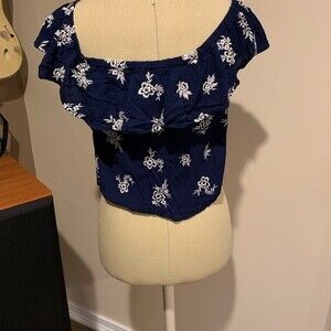 Full Tilt size medium blue ruffled crop top with white flowers.